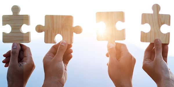 Hands holding up jigsaw pieces